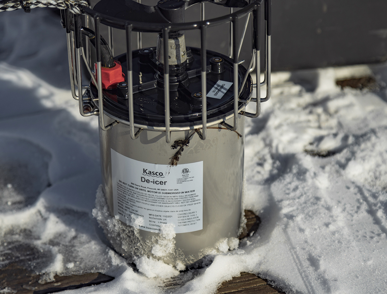Close-up of a Kasco De-icer resting on a snow-covered dock